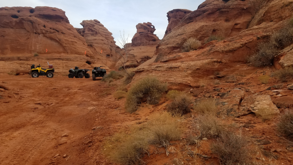 ATVs on red sandstone desert trail.
