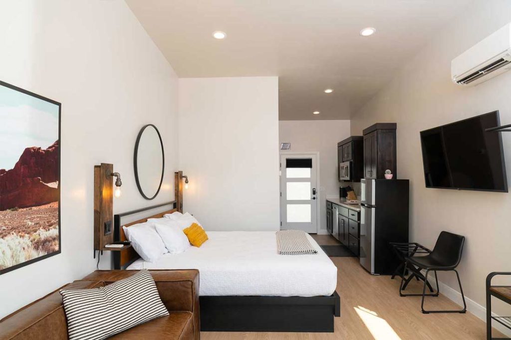 Modern hotel room with stylish decor and kitchenette.