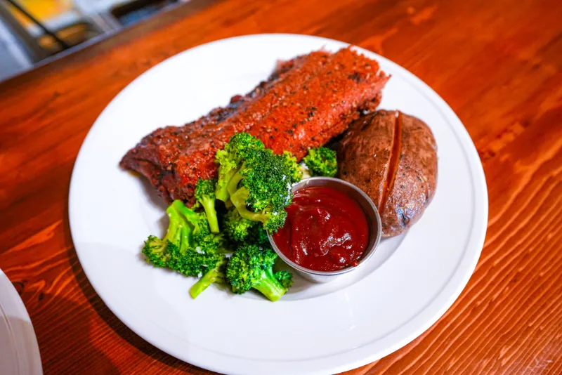 Grilled meat with broccoli and sauce on plate