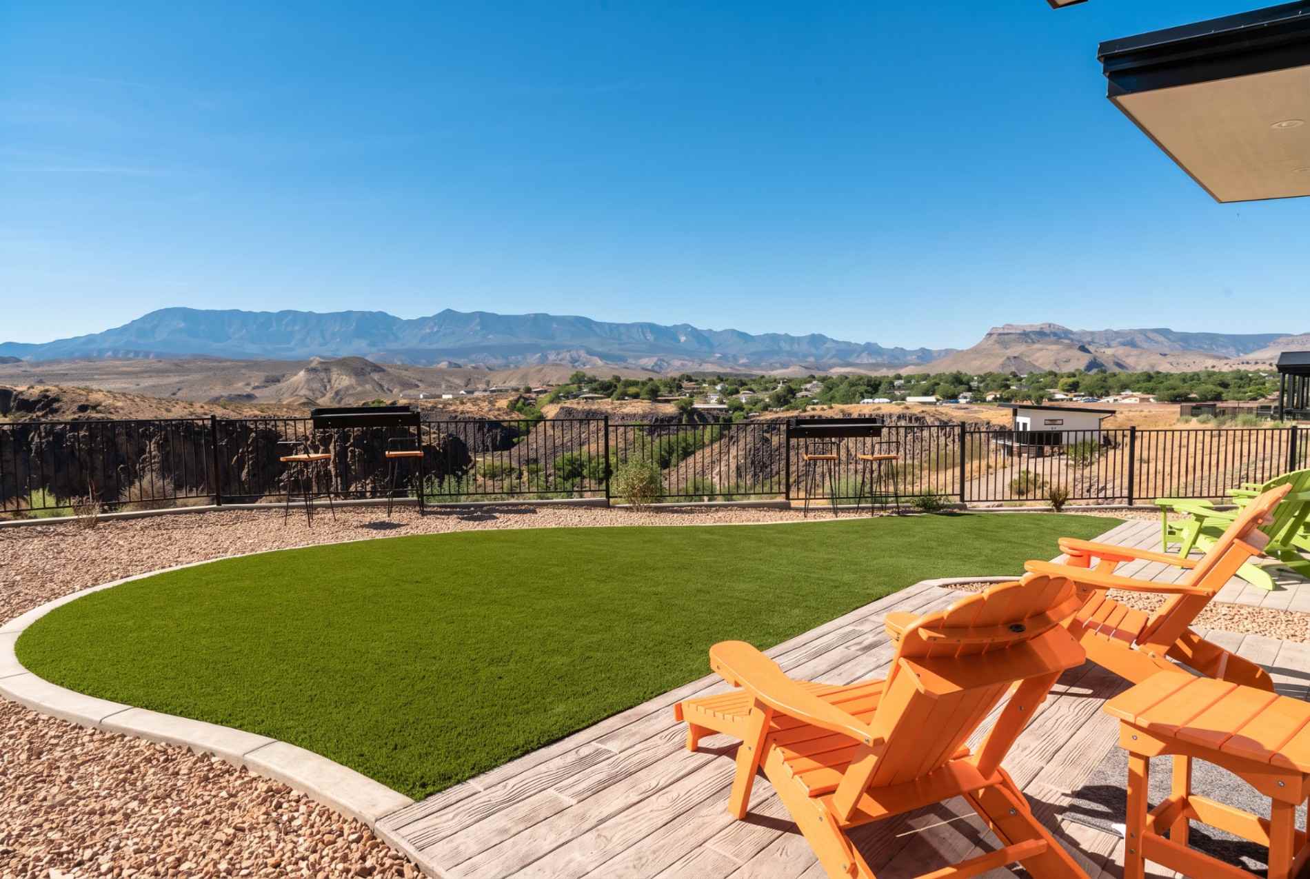 Private patio at The Dwellings in La Verkin with orange chairs, a fenced yard, and mountain views toward Zion.