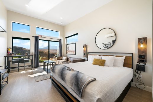 Modern bedroom with mountain view and balcony access.