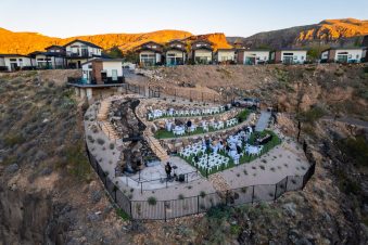 Outdoor wedding setup near luxury homes at sunset.