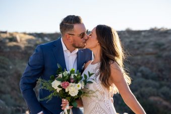 Couple kissing at outdoor wedding ceremony.