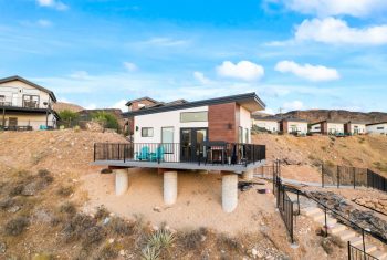 Modern stilt house in suburban hillside area.