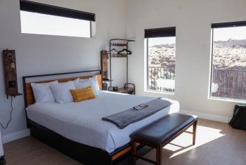 Modern bedroom with scenic desert view through windows.