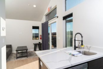 Modern kitchen interior with natural light and scenic view.