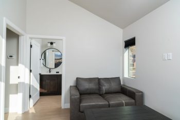 Modern living room with couch and open door.