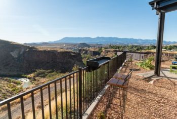 Scenic canyon view from mountain balcony with railing.