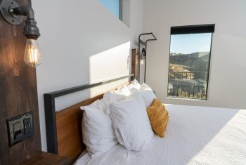 Cozy modern bedroom with natural light and scenic view.