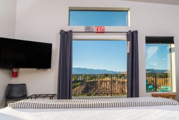 Hotel room with mountain view and exit sign.