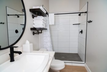 Modern bathroom with black fixtures and white tiles.