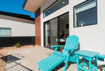 Modern home exterior with cozy patio chairs.
