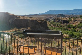 Scenic overlook with chairs and mountain view.
