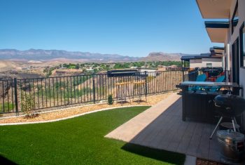 Backyard patio with mountain view and artificial grass.