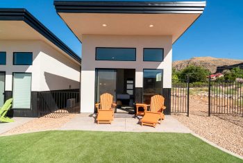 Modern backyard with Adirondack chairs and mountain view.