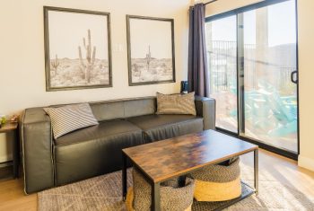Modern living room with leather sofa and desert art.