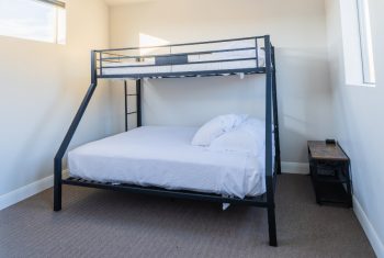 Black metal bunk bed in a bright room.