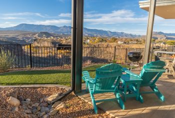 Backyard patio with mountain view and Adirondack chairs.