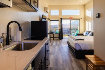 Modern studio apartment with mountain view balcony.