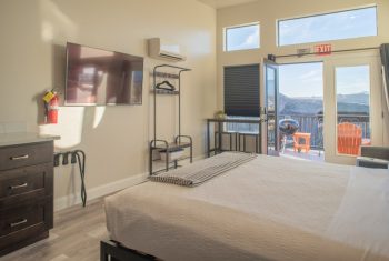 Modern hotel room with balcony and mountain view.