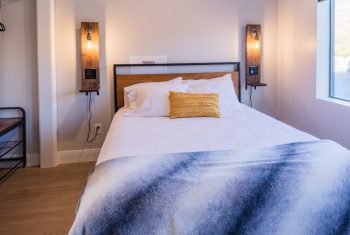 Modern bedroom with cozy bed and stylish wall lamps.