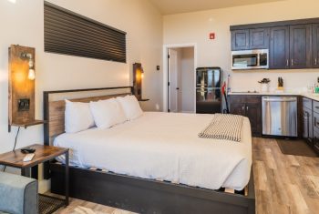 Modern studio apartment interior with bed and kitchen.