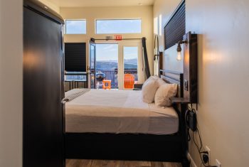 Cozy bedroom with balcony mountain view.