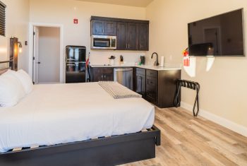 Modern studio apartment with kitchen and flat-screen TV.